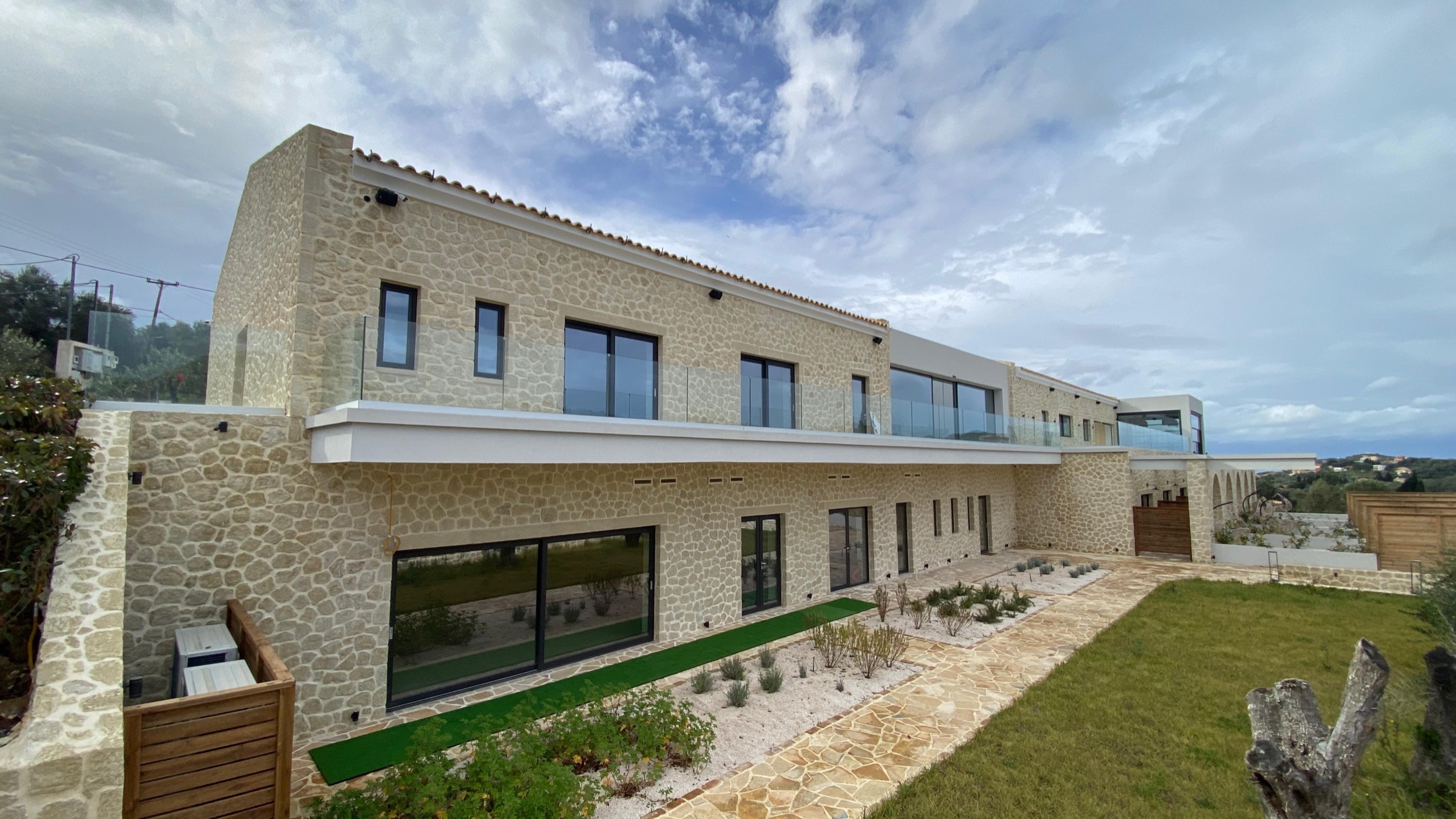 Villa No. 5, A villa complex in Corfu fieldstone, opening through a colonnade of round stone arches.